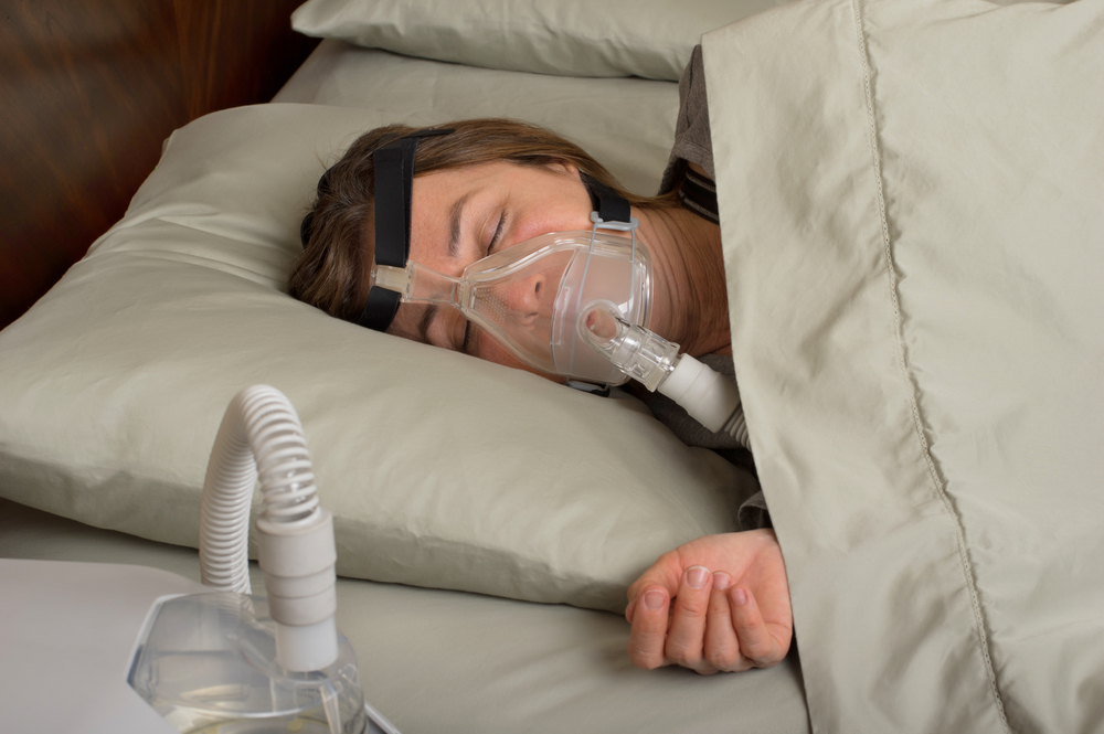 woman sleeping with CPAP machine
