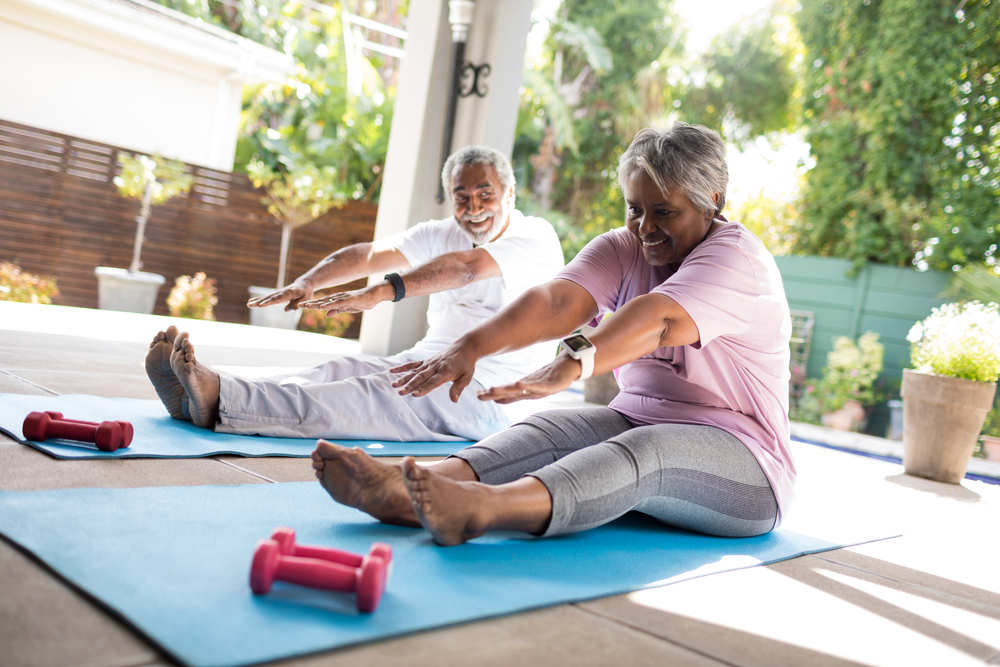 Senior couple stretching on yoga mats