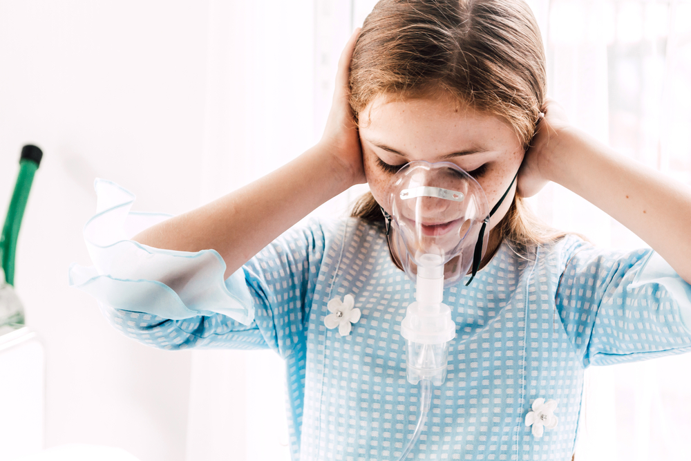 Young girl wearing nebulizer mask