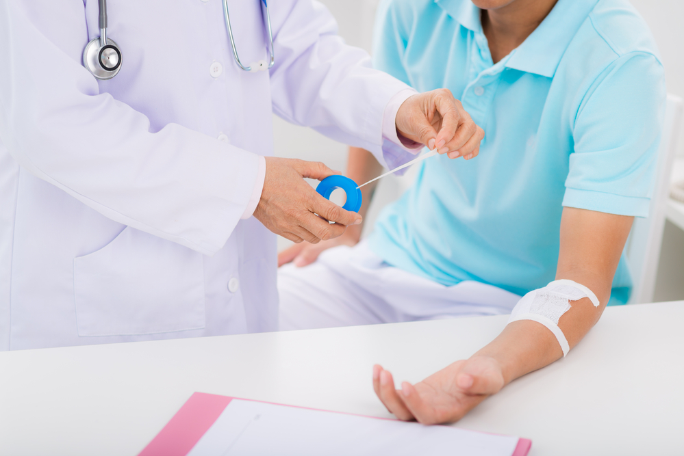 Doctor changing bandage on man's forearm